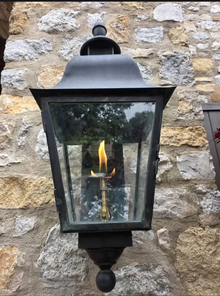 Open flame burning inside a natural gas lamp at dusk