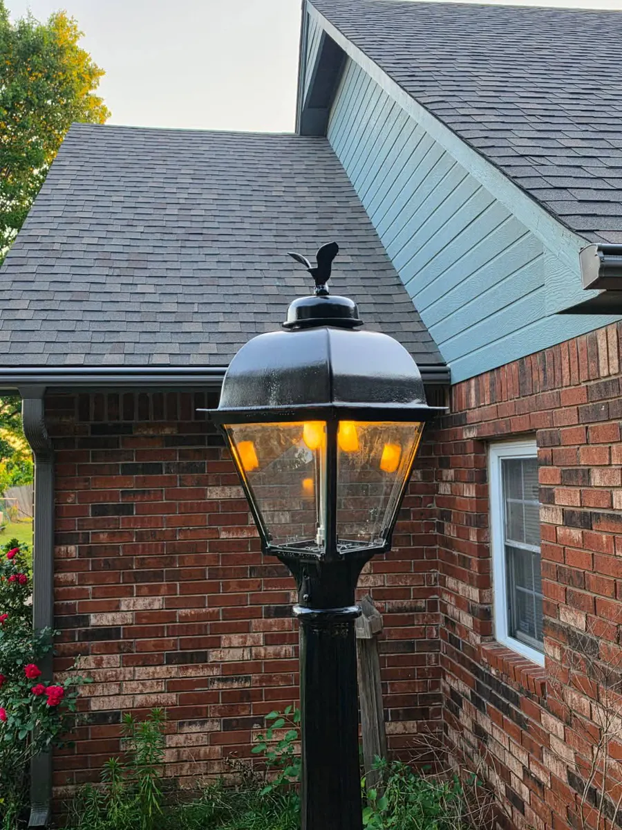 Gas lamp lighting a home entry at dusk