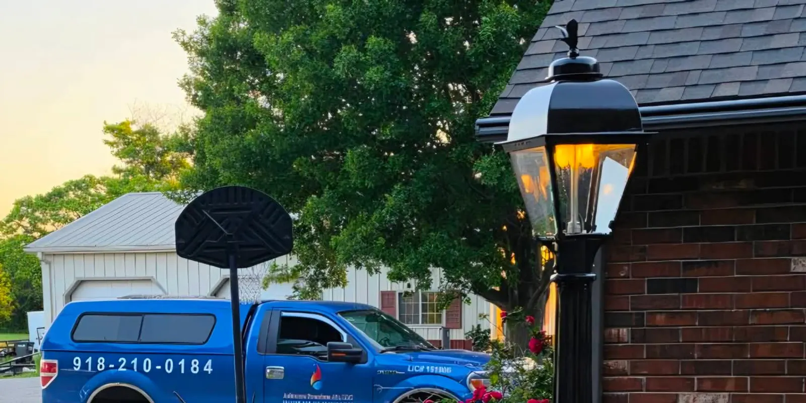 Ashmore Premium Air service truck parked beside a lit gas lamp post at dusk in Tulsa, Oklahoma